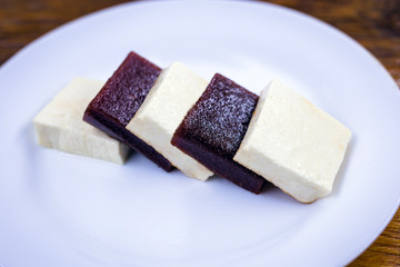 Brazilian dessert known as Romeo and Juliet. Sliced ​​cheese with pieces of guava on white plate.