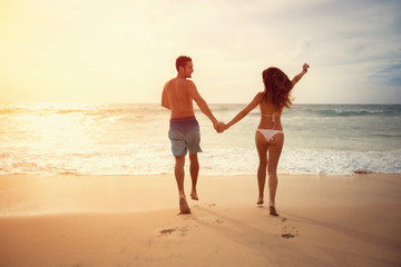 Young couple running on the beach