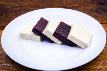 Brazilian dessert known as Romeo and Juliet. Sliced ​​cheese with pieces of guava on white plate.