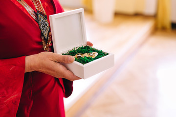 Woman in a red dress holds a box with wedding rings. engagement.
