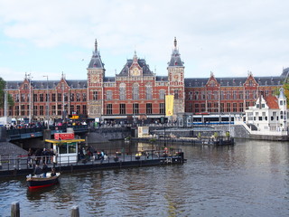 Obraz premium a scenery of amsterdam (central station, canal, trams and pier)