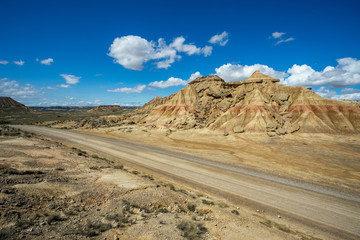 une route dans le désert des Bardenas devant une montagne ocre