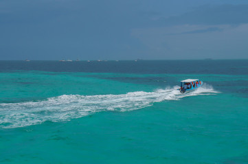 Fototapeta premium Boat in blue Caribbean sea at Isla Mujeres in Quintana Roo, Mexico 