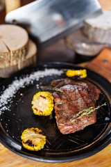 Grilled steak with corn and rosemary. Restaurant serving