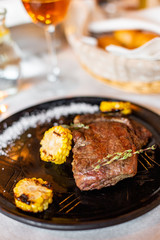 Grilled steak with corn and rosemary. Restaurant serving
