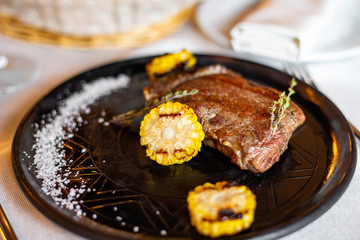 Grilled steak with corn and rosemary. Restaurant serving