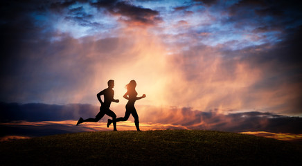 Young couple run together on a sunset