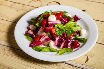 salad of lettuce, red cabbage, mozzarella, strawberry