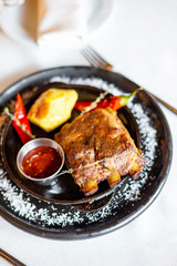 Fried ribs with potatoes, red pepper and sauce