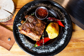 Fried ribs with potatoes, red pepper and sauce