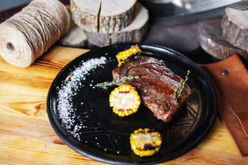 Grilled steak with corn and rosemary. Restaurant serving