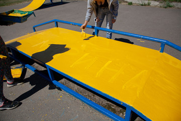 The girl paints with a metal brush. Yellow paint. Hand holds brush. Paint work. Repair and...