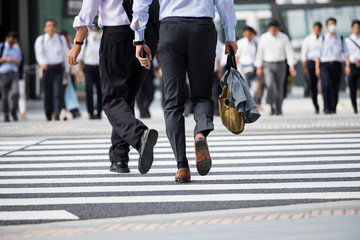横断歩道を渡るビジネスマンの後ろ姿