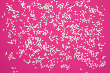 Holographic stars confetti on pink bright background. Festive backdrop for your projects