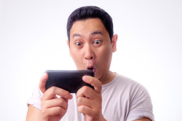 Funny Young Asian Guy Playing Games on Tablet Smart Phone