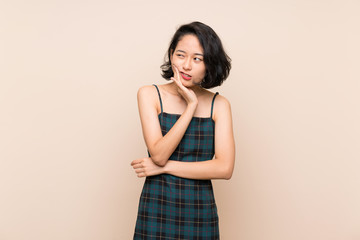 Asian young woman over isolated yellow wall with toothache