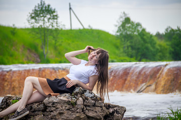 The girl at the waterfall. Young beautiful girl on a little waterfall. Little waterfall.