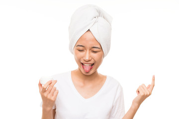 Asian young woman over isolated background with moisturizer