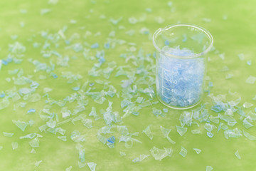 Bottle flake,PET bottle flake,Plastic bottle crushed,Small pieces of cut blue plastic bottles in beaker glass.Chemical concept