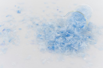 Bottle flake,PET bottle flake,Plastic bottle crushed,Small pieces of cut blue plastic bottles in beaker glass.Chemical concept