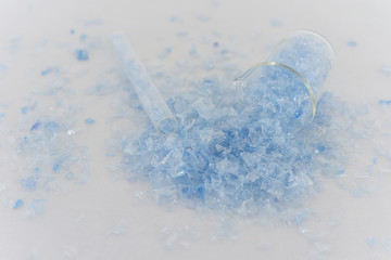 PET bottle flakes, Plastic bottle crushed, Small pieces of cut blue plastic bottles in beaker glass 