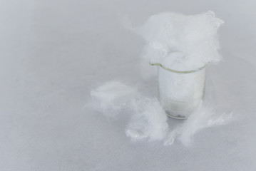 White Polyester stable fiber fabric in beaker glass with white background