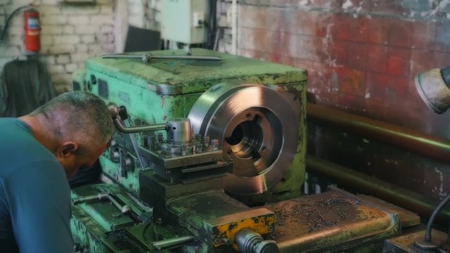 Plant - the man adjusts the lathe with the help of levers