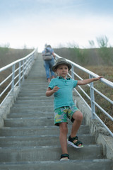 A little boy walks up the long stairs.