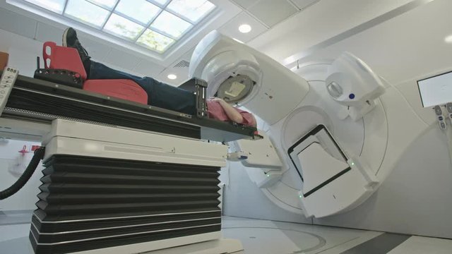 Patient Getting Radiation Therapy Treatment Inside A Modern Radiotherapy Room