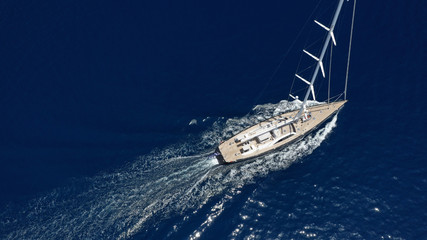 Aerial photo of beautiful luxury sail boat with wooden deck cruising the deep blue Aegean sea, Greece