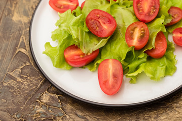 plate of salad with cherry tomatoes and lettuce. dressing with olive oil. Dietary food. Copy space
