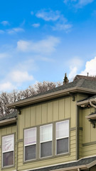 Vertical frame Exterior view of the upper storey of a house against cloudy blue sky in winter