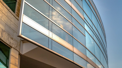 Fototapeta na wymiar Panorama frame Exterior of a modern building seen from below with blue sky background