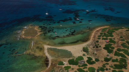 Aerial view of small islet of Ydrousa with turquoise and sapphire clear waters and only one mile distance from coast in Voula, Athens riviera, Attica, Greece