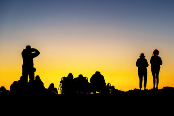 Fototapeta premium Silhouette of crowd enjoying the sunset atop Mount Haleakala on Maui, Hawaii