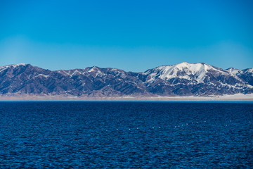The frozen Sailimu lake with snow mountain background at Yili, Xinjiang of China