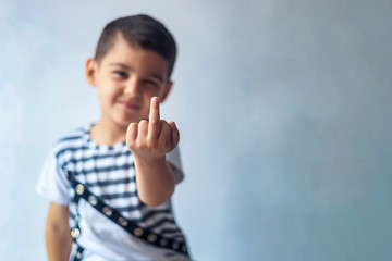 Six-year-old boy showing middle finger. 6-year kid hand gesturing with his middle finger. Obscene...