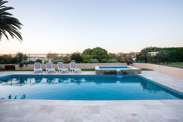 Luxury swimming pool with a small fountain covered with fence