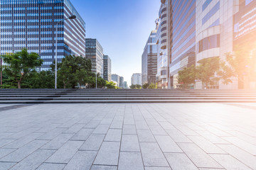 Fototapeta premium Panoramiczna panorama i nowoczesne biurowce biznesowe z pustą drogą, pustą betonową kwadratową podłogą