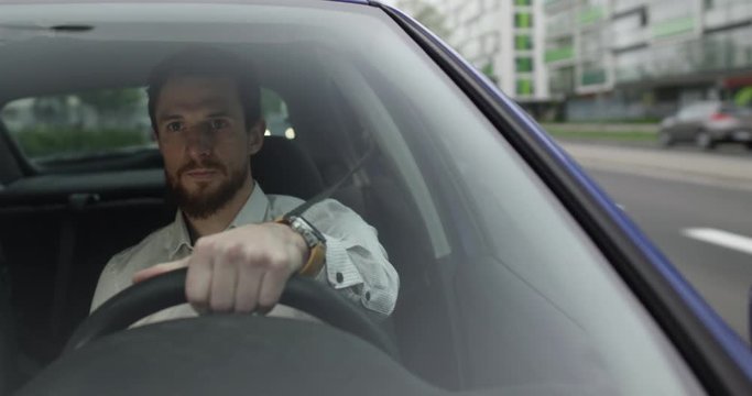 Male uber driver drives fast and talks to his passenger inside the car