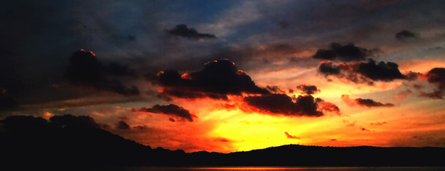 Stormy dark stratocumulus cloud in a bright sunset sky.