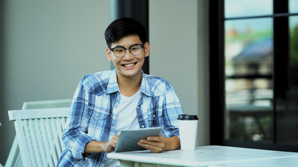 Young man using tablet with big smile looking to camera