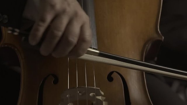 Professional cellist playing on stage close up