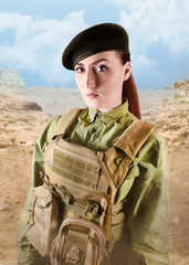 Young beautiful soldier woman in miliary beret and protective armor tactical vest on desert background.