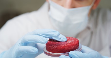 Portrait of an young scientist is inspecting and analyzing the cultured artificial meat sample in...