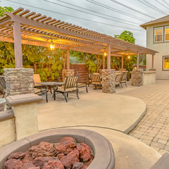 Square frame Patio with dining area and built in circular benches wrapped around a fire pit
