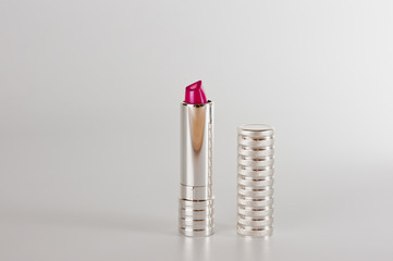 Red bright lipstick in silver metallic tube closeup shot