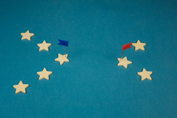 wooden cubes in the form of stars lined up in a chain and one star with a red flag, the star with...