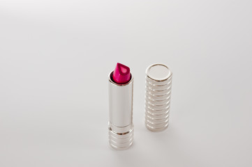 Red bright lipstick in silver metallic tube closeup shot