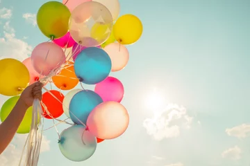 Selbstklebende Fototapete Ballon Hand, die mehrfarbige Luftballons hält, die mit einem Retro-Vintage-Instagram-Filtereffekt gemacht wurden.